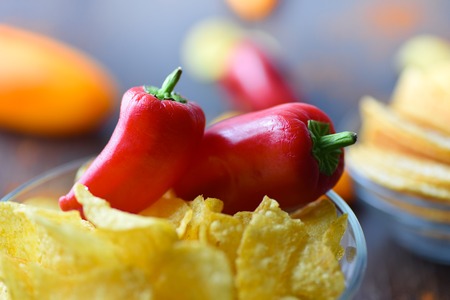 Potato chips with paprika on dark wooden backgroundの写真素材