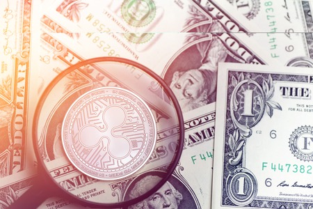 shiny golden RIPPLE cryptocurrency coin on blurry background with dollar money 3d illustrationの写真素材