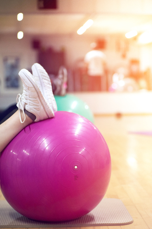exercising with personal trainer on large stability ball in studio fitness back physiotherapyの写真素材
