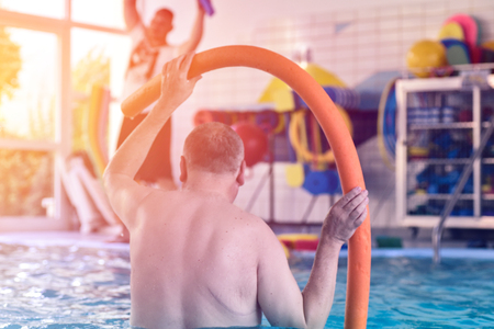 Group or young and senior people in aquarobic fitness swimming pool exercising water sportの写真素材