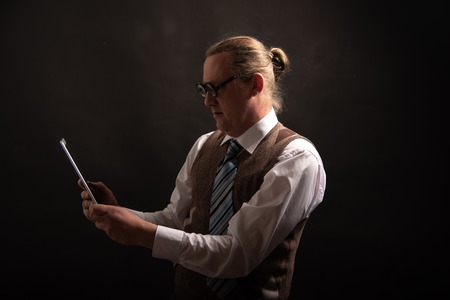 Funny nerd or geek looking on tablet with empty placeholderの写真素材