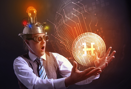 distraught looking conspiracy believer in suit with aluminum foil head with HDAC cryotocurrency coinの写真素材