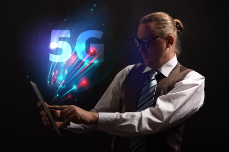 Funny nerd or geek wiith tablet and 5G symbolの写真素材