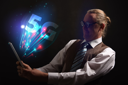 Funny nerd or geek wiith tablet and 5G symbolの写真素材