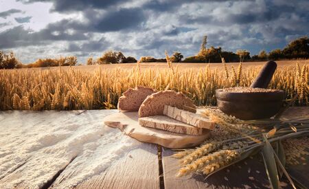 bread flour and corn on a old table with cornfield in the backgroundの写真素材
