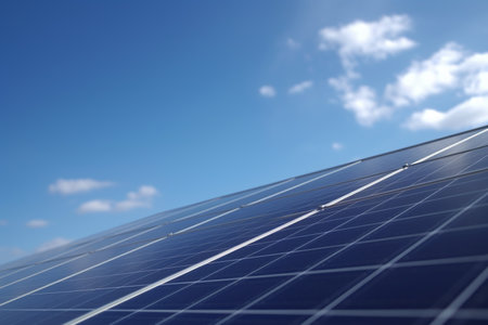 A view of solar panels installed on a rooftop against a blue sky with clouds in the backgroundの素材