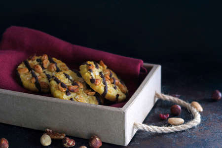 Chocolate cookies with nuts on red dishtowel in wooden box.の写真素材