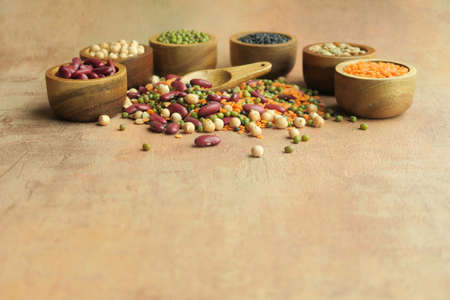 Various raw legumes in wooden bowls.の写真素材