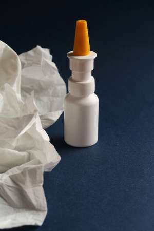 Nasal spray and tissues on blue background. First help in the season of cold and flu.の写真素材