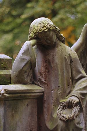 A sculpture of the mourning angel. Old graveyard.の写真素材