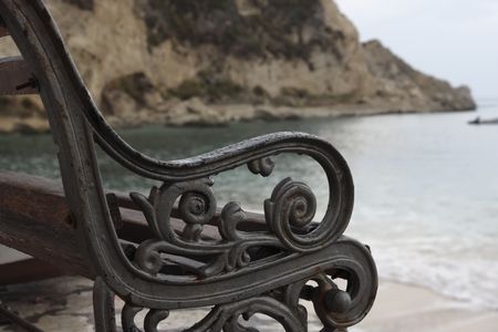Fragment of the wet beach bench early in the morning.の写真素材