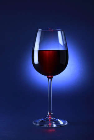 Glass of red wine on the blue background.の写真素材