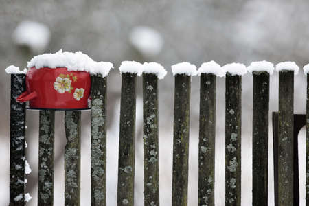 Red metal pot on the fence.の写真素材