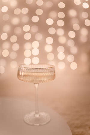 A glass of champagne is on the table and blurred lights.の写真素材