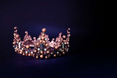 Beautiful golden queen crown on dark background in low key, space for text.の写真素材