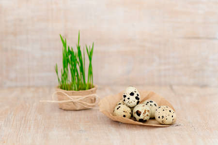 Easter eggs on craft paper on a wooden background with green sprouts.の写真素材