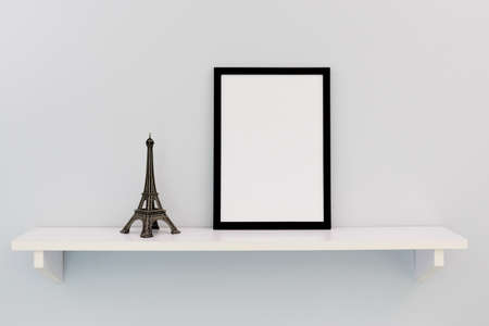 A black vertical frame with copy space stands on a shelf, next to the Eiffel Tower.