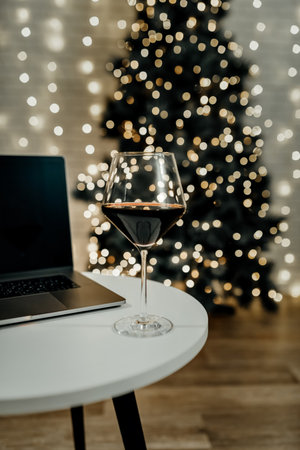 A glass of wine is on the table with an open laptop. The concept of rest, finishing work.の写真素材