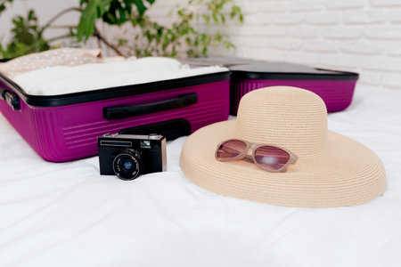 An open suitcase with women's clothes on the bed is collected for travel.の写真素材