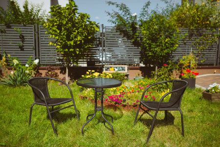 Garden medel, two chairs and a table stand on the lawn in the courtyard, a place to relax.の写真素材