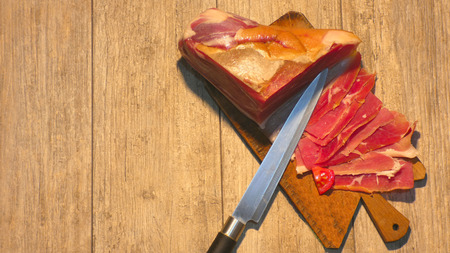 On a wooden cooker sliced ??prosciuttoの写真素材
