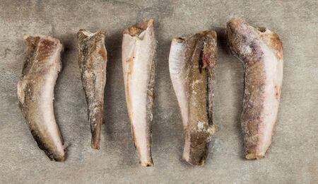 Cracked carcasses of frozen fish on a gray backgroundの写真素材