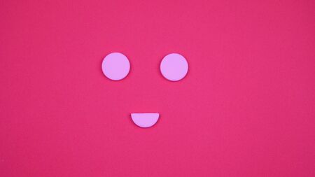 Composition of pills and capsules on a pink background in the form of a smile. Happy emotions. Psychological help. Good day.の写真素材