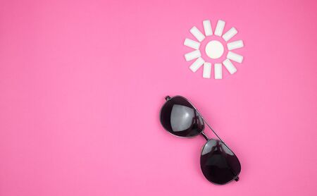 chewing gum on a light pink background. set out in the form of the sun. Bottom of sunglasses.