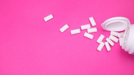 Gum chewing Background. chewing gum spilled from a pack on a pink background. top view. copy spaceの写真素材