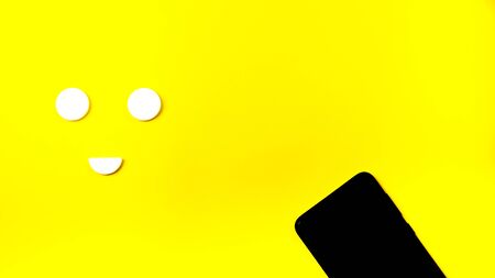 black phone sunglasses on yellow background. top view copy spaceの写真素材