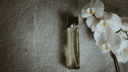 bottle of cologne, flowers on a gray background, Top view