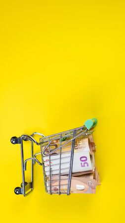 empty empty basket on euro banknotes, on yellow background. Concept of food basket or purchasing power.の写真素材