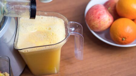 Juicer and orange juice on wooden background.