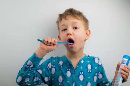 Portrait of young man with toothbrush on a white background.