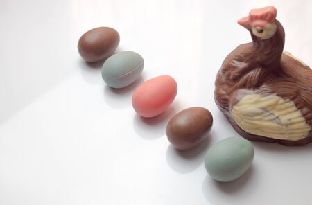 colored chocolate eggs, and chocolate chicken on a white background.