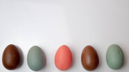 colored chocolate eggs on a white background.