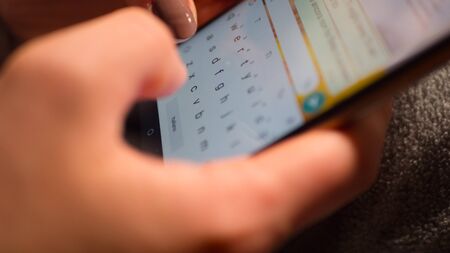 woman with brown nails writes sms on phone.