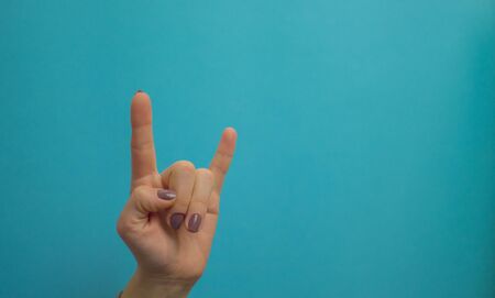 woman hand pointing up well, yes, taking hand sign aside, isolated on blue background.の写真素材