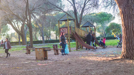mother swings son on a swing in the park.
