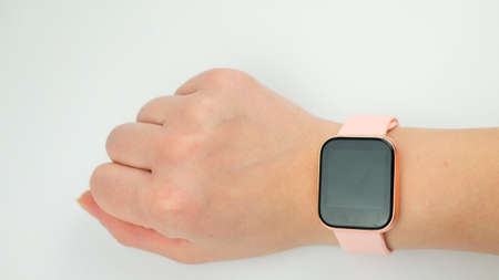 Youth watch on womans wrist. Smart watch on white background, black blank display.の写真素材