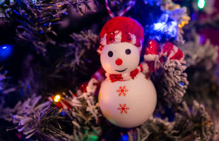 Classic Christmas tree with a flashing garland in a dark room. Christmas interior background.