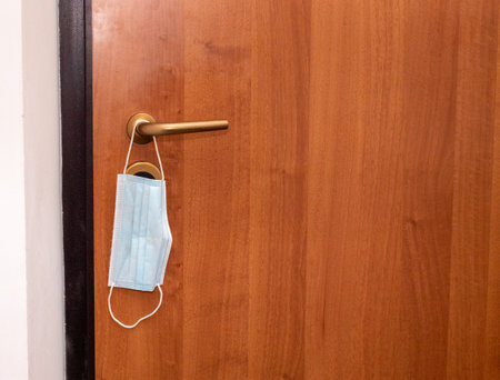 a face mask hanging on the door handle. Coronavirus masks COVID19. Antivirus masksの写真素材