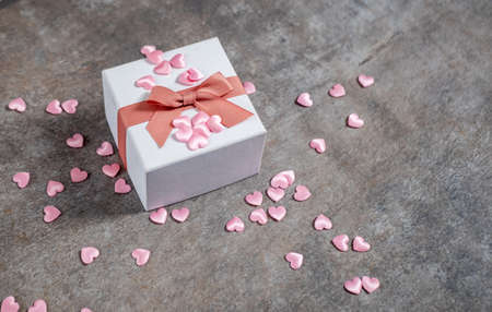 view of a gift box, pink hearts around, top view