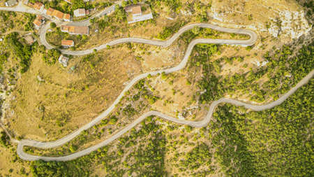 swirling road view from aerial view. A winding road climbs to the top of the city