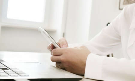 at workplace using smartphone, texting, choose and buy goods and services online, concept of using...