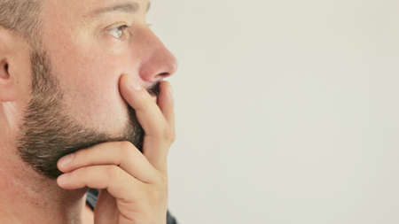 a thoughtful young man, close-up on a white background