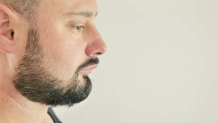 View profile of a thinking young man. close up on white backgroundの写真素材