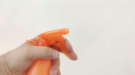 male hand holding flower sprayer with water isolated on white backgroundの写真素材