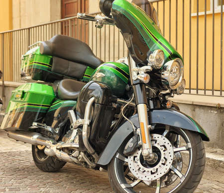 old retro motorcycle traveling through city streetsの写真素材