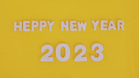 2023 word is made of wooden blocks on the yellow background . Happy New Year. New year and holiday...